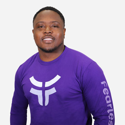 man smiling and wearing purple fearless long sleeve