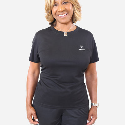 woman wearing the black performance shirt with the fearless logo